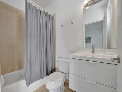 a bedroom with a bed a ceiling fan and a large window