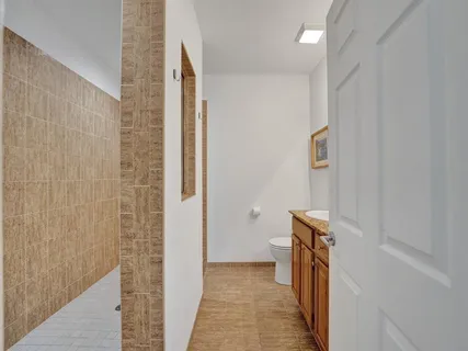 a spacious bathroom with a toilet sink and mirror