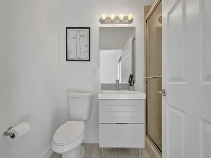 a bathroom with a shower sink and mirror