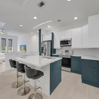 a kitchen with stainless steel appliances kitchen island granite countertop a stove a sink a microwave a dining table and chairs