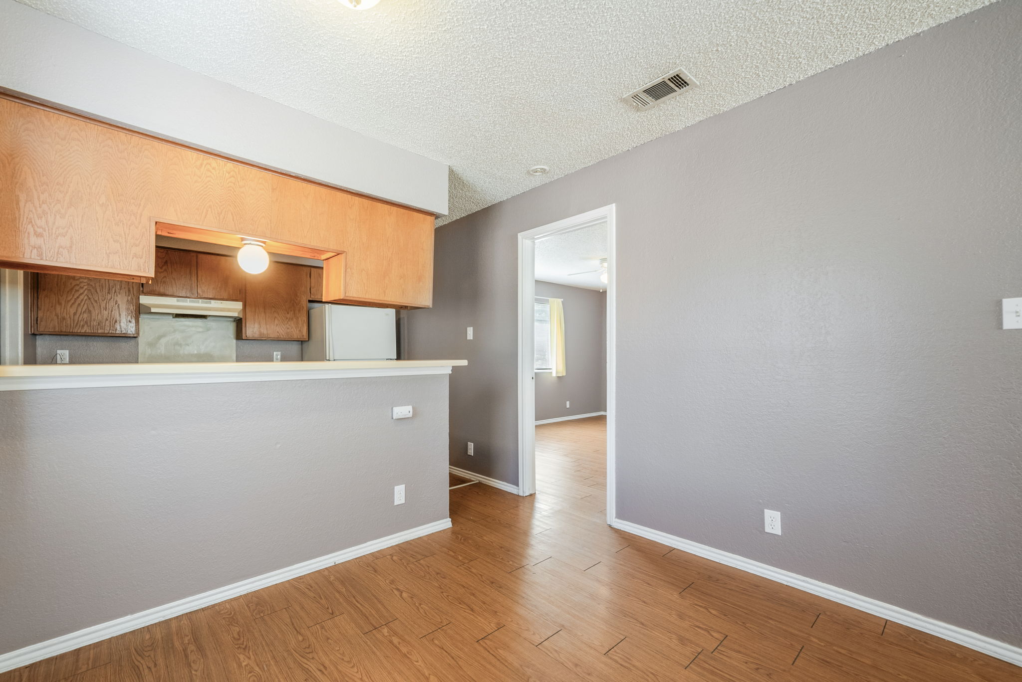 5807 Spring Meadow Road, Unit B Austin, TX 78744 - Photo 8 of 31 A well-lit kitchen area features warm wood cabinetry and durable wood flooring.