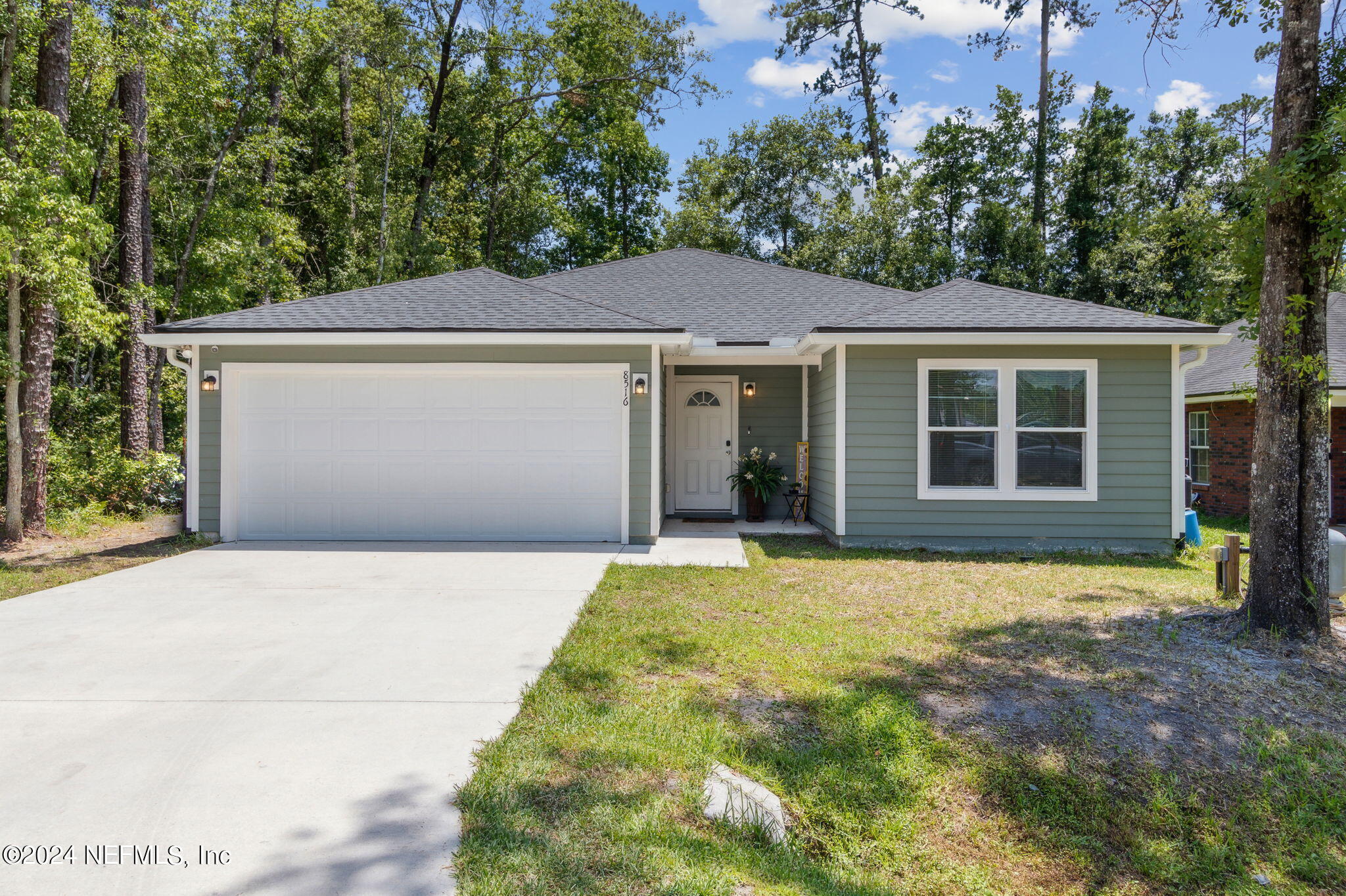 8516 April Street Jacksonville, FL 32244 - Photo 1 of 26 a front view of a house with a garden and yard