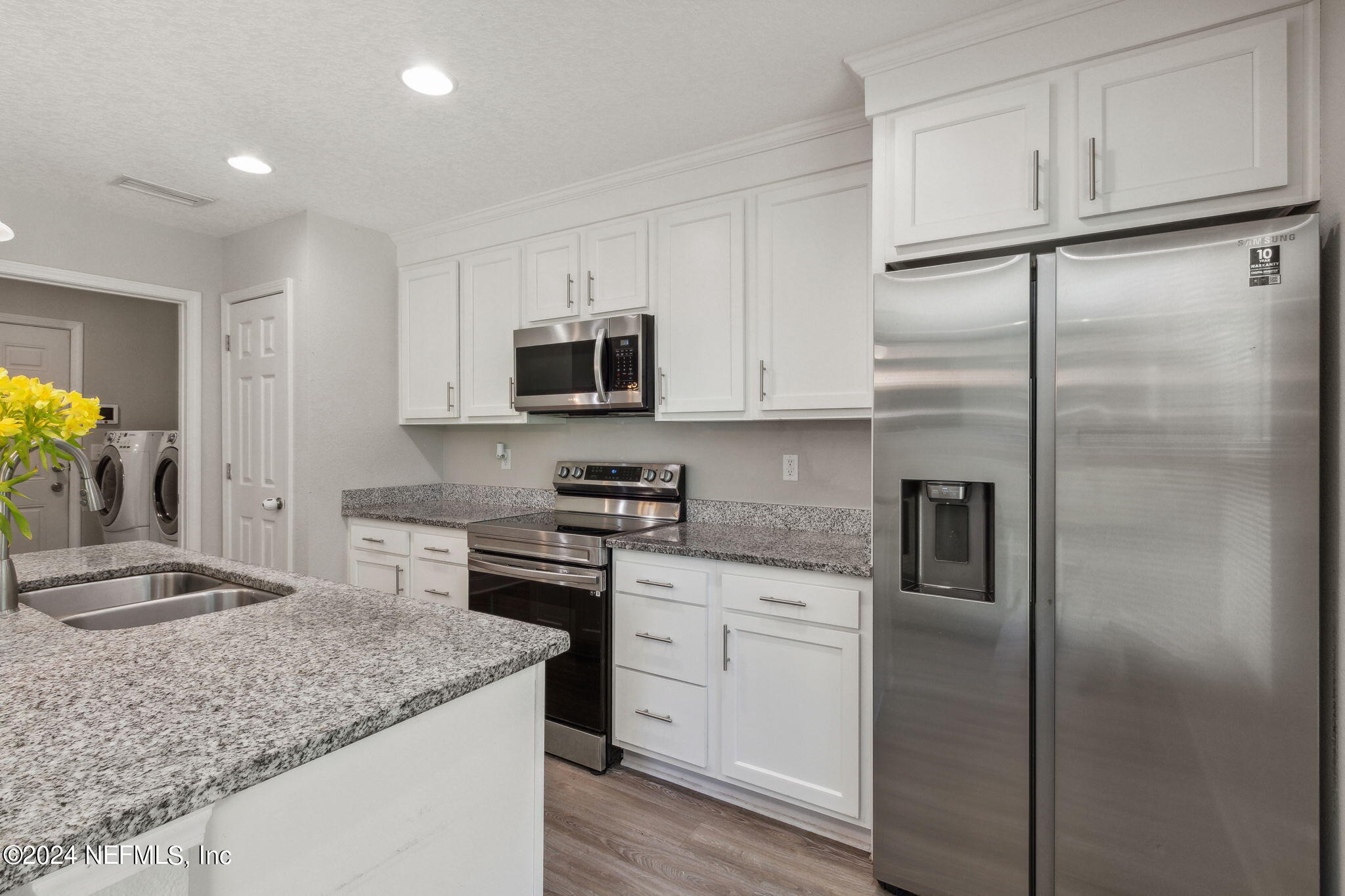 8516 April Street Jacksonville, FL 32244 - Photo 11 of 26 a kitchen with kitchen island granite countertop a sink stove and refrigerator