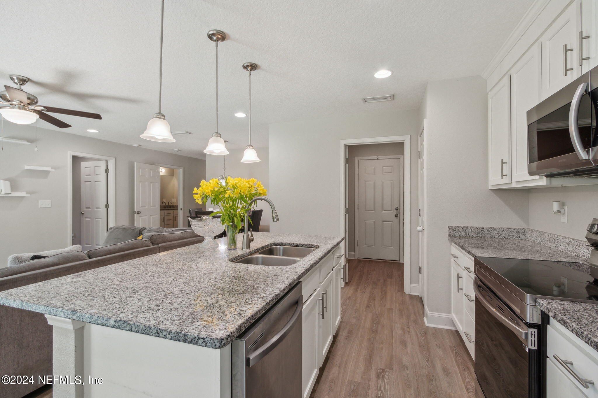 8516 April Street Jacksonville, FL 32244 - Photo 12 of 26 a kitchen with stainless steel appliances granite countertop counter space a sink cabinets and wooden floor