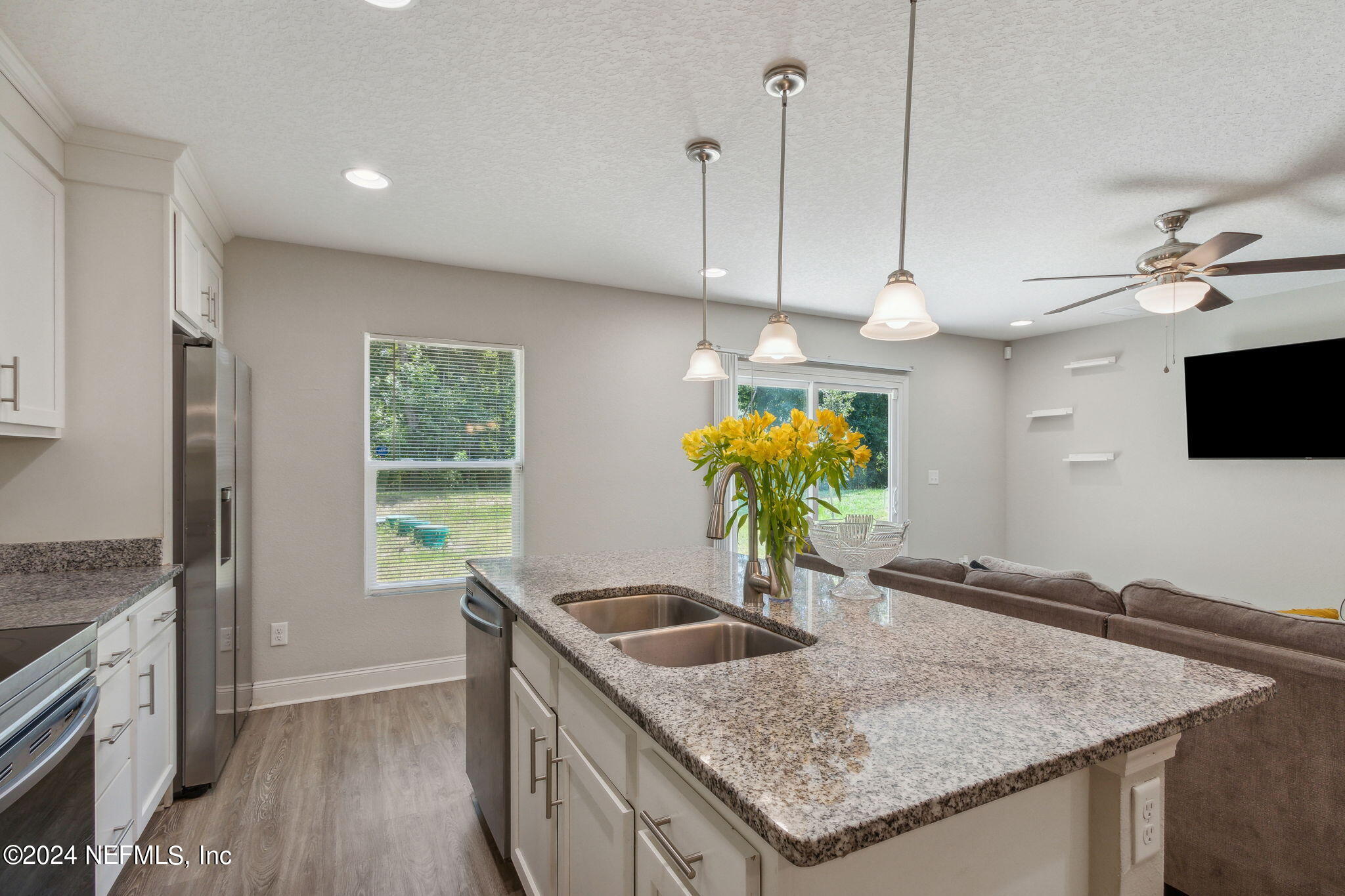 8516 April Street Jacksonville, FL 32244 - Photo 10 of 26 a kitchen with stainless steel appliances granite countertop a sink a stove and a wooden floor
