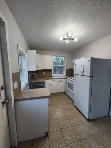 a kitchen with a refrigerator a sink and cabinets