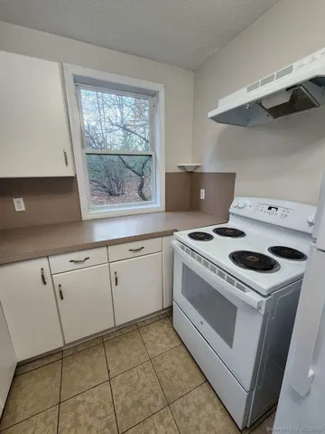 a white stove top oven sitting inside of a kitchen