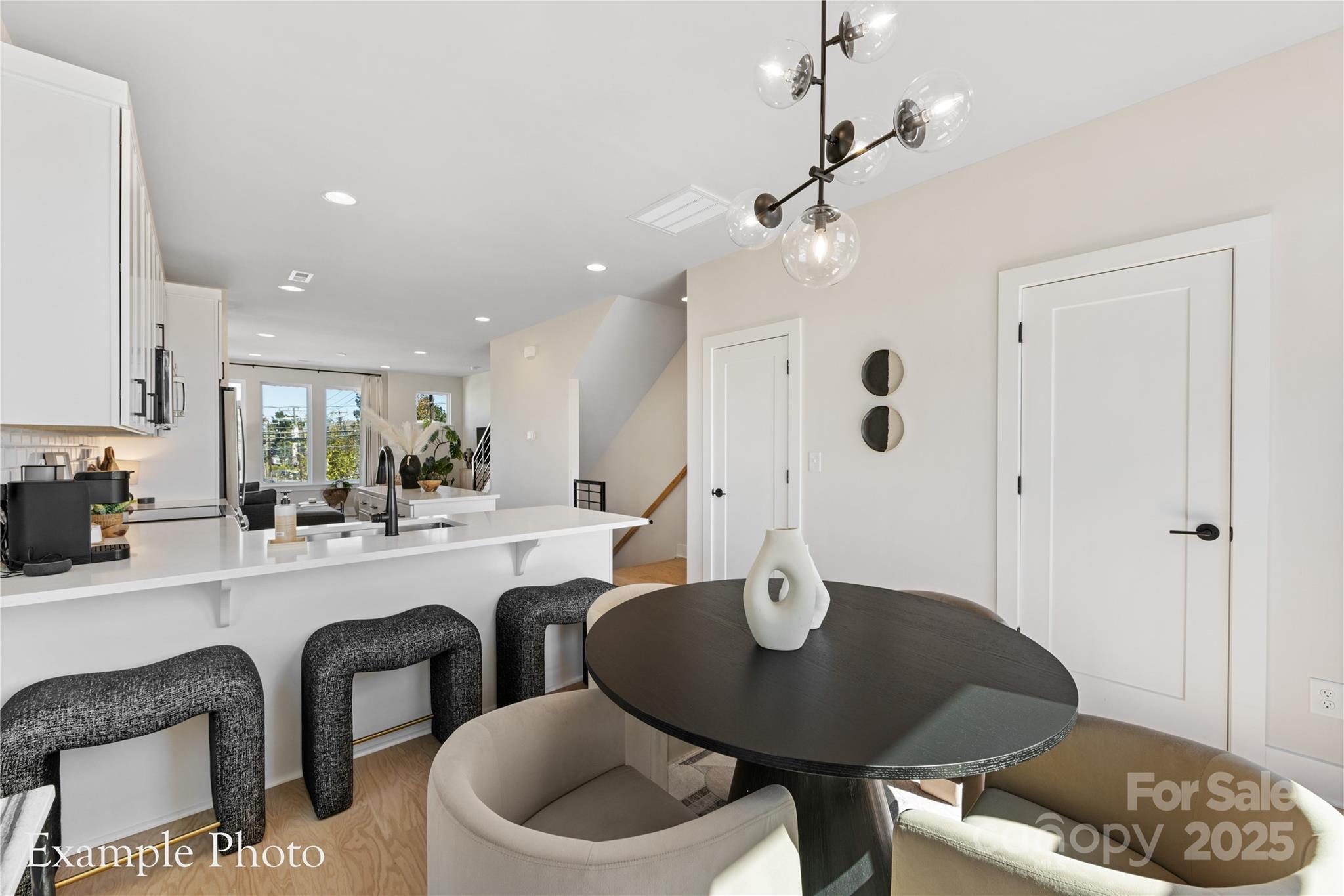 548 Rountree Road, Unit 9 Charlotte, NC 28217 - Photo 17 of 36 a kitchen with a dining table chairs sink and cabinets