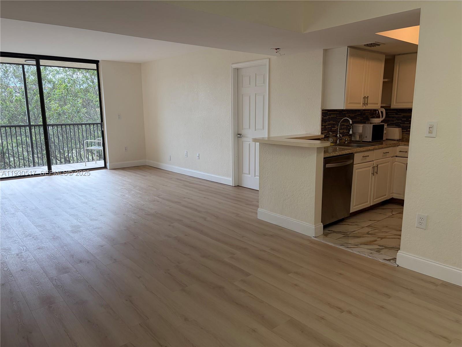 a kitchen with granite countertop a stove a sink and a wooden floor