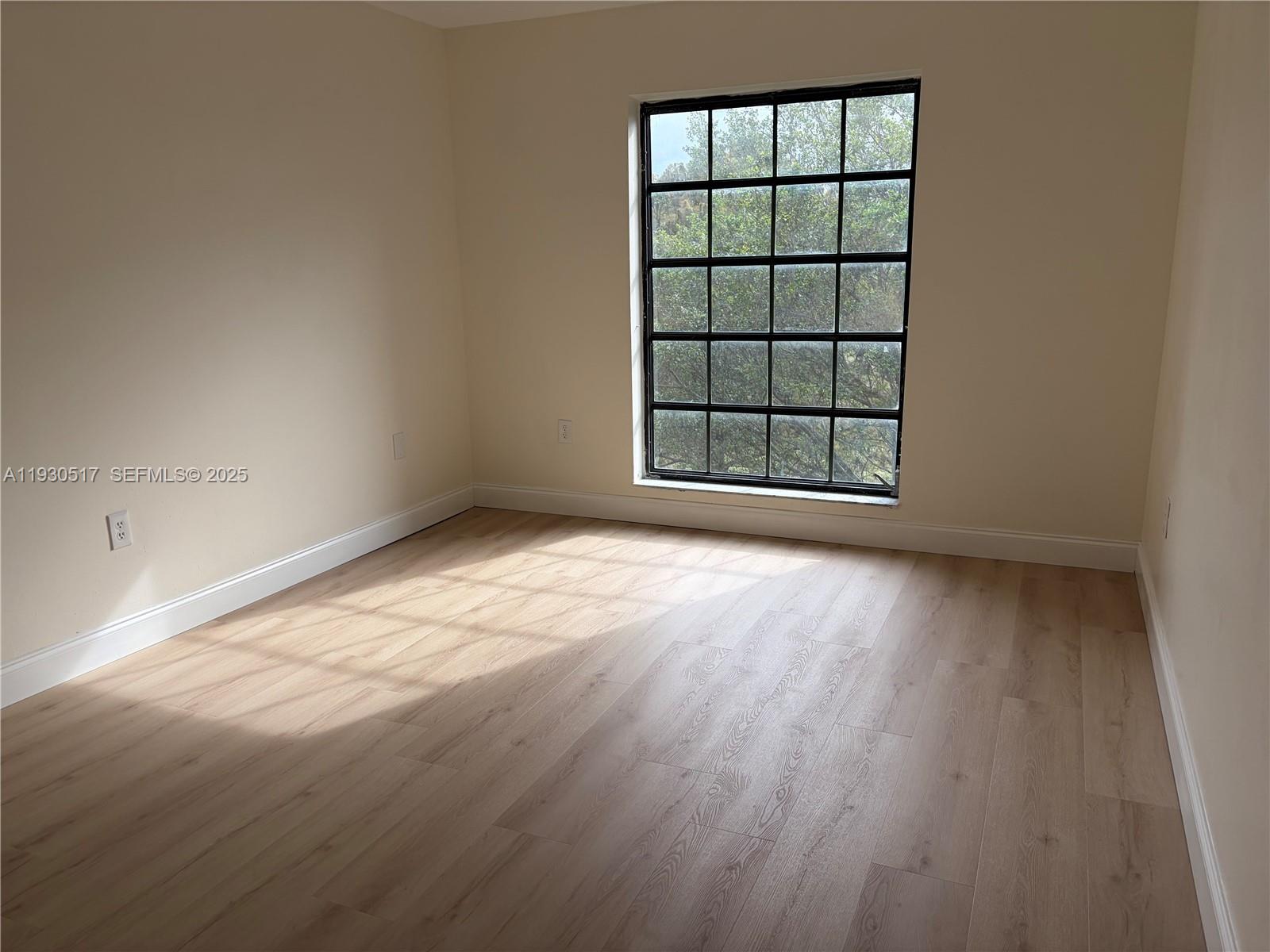 5550 Northwest 44th Street, Unit 414B Lauderhill, FL 33319 - Photo 7 of 17 an empty room with wooden floor and windows