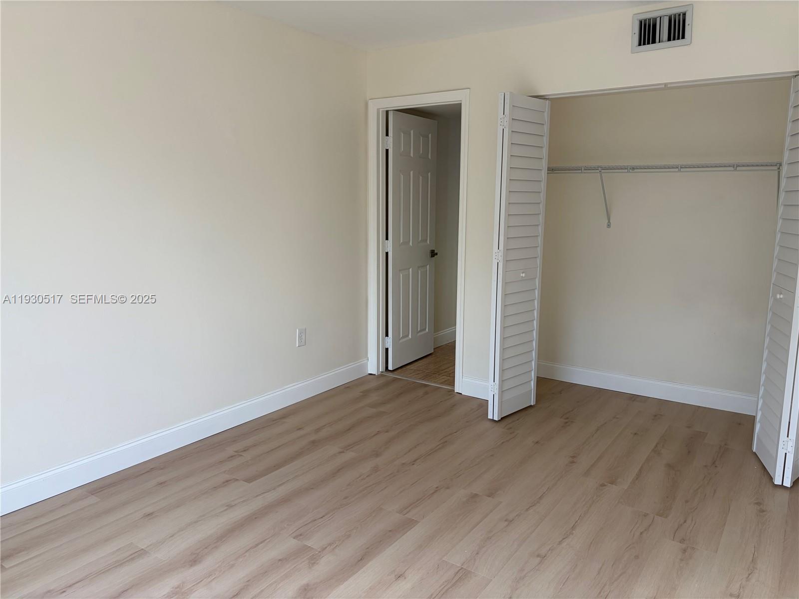 5550 Northwest 44th Street, Unit 414B Lauderhill, FL 33319 - Photo 10 of 17 an empty room with wooden floor and closet