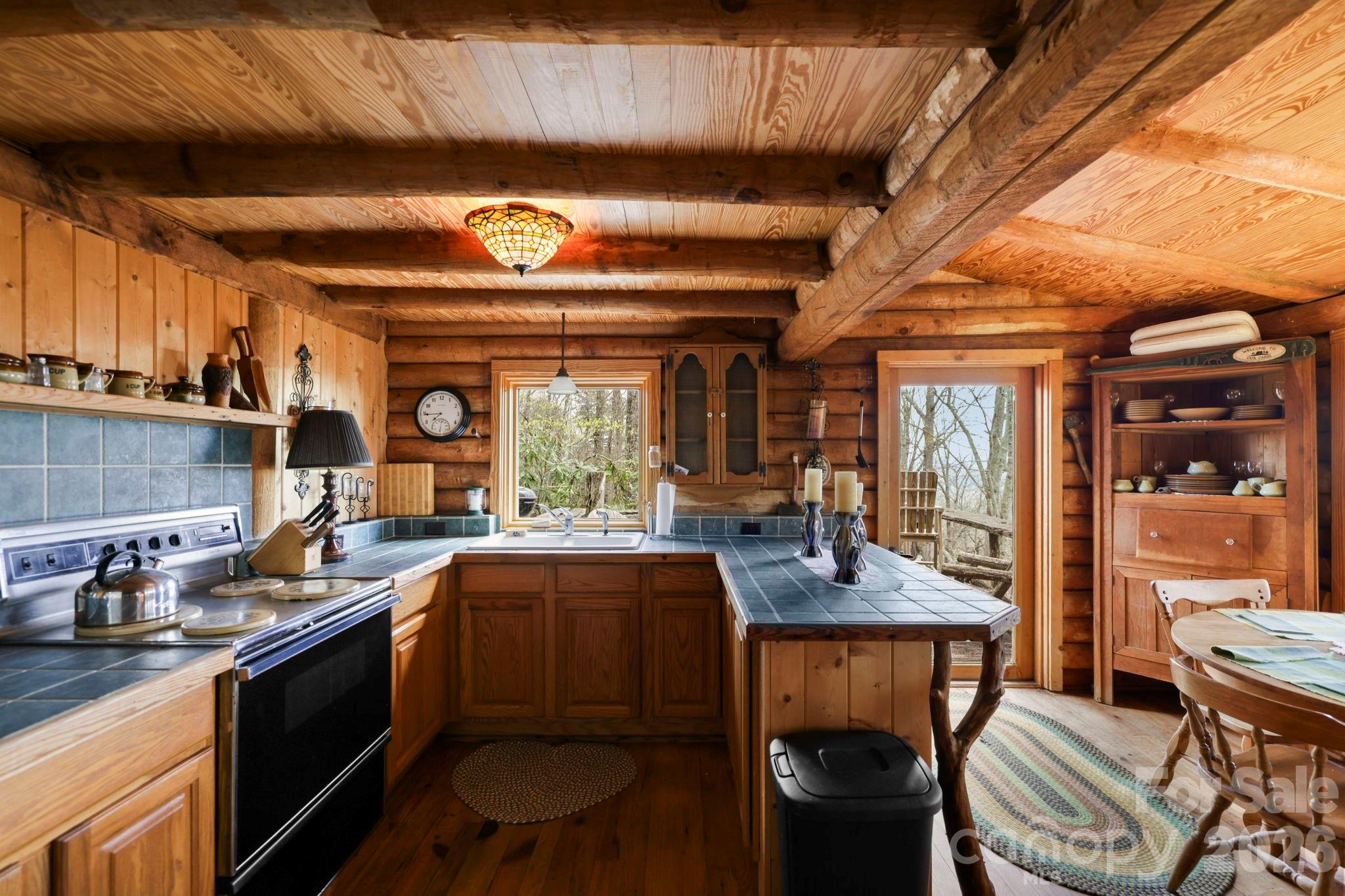 305 Stamey Creek Road Brevard, NC 28712 - Photo 14 of 32 a kitchen with a sink and chairs