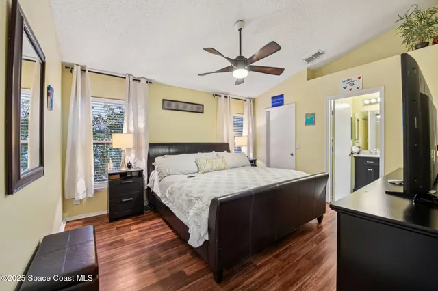 a spacious bedroom with a large bed and a chandelier