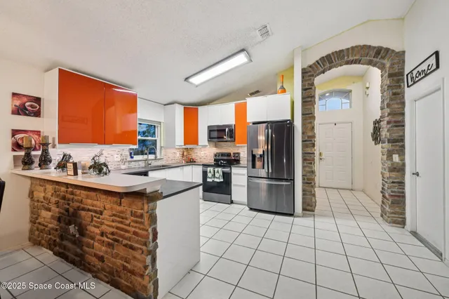 a kitchen with a sink a counter top space and stainless steel appliances