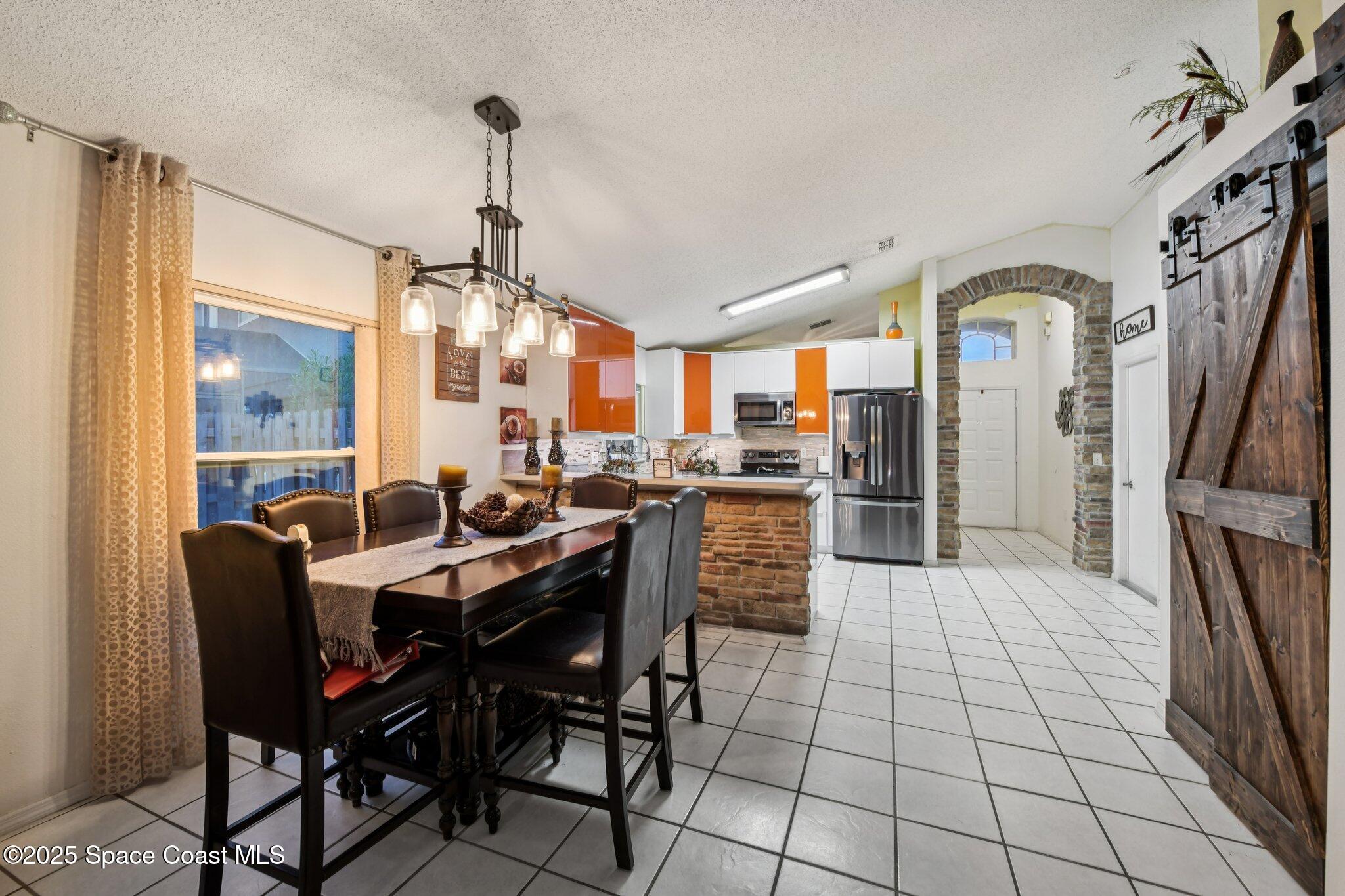 1125 Carey Glen Circle Orlando, FL 32824 - Photo 8 of 31 a dining hall with stainless steel appliances a dining table and chairs