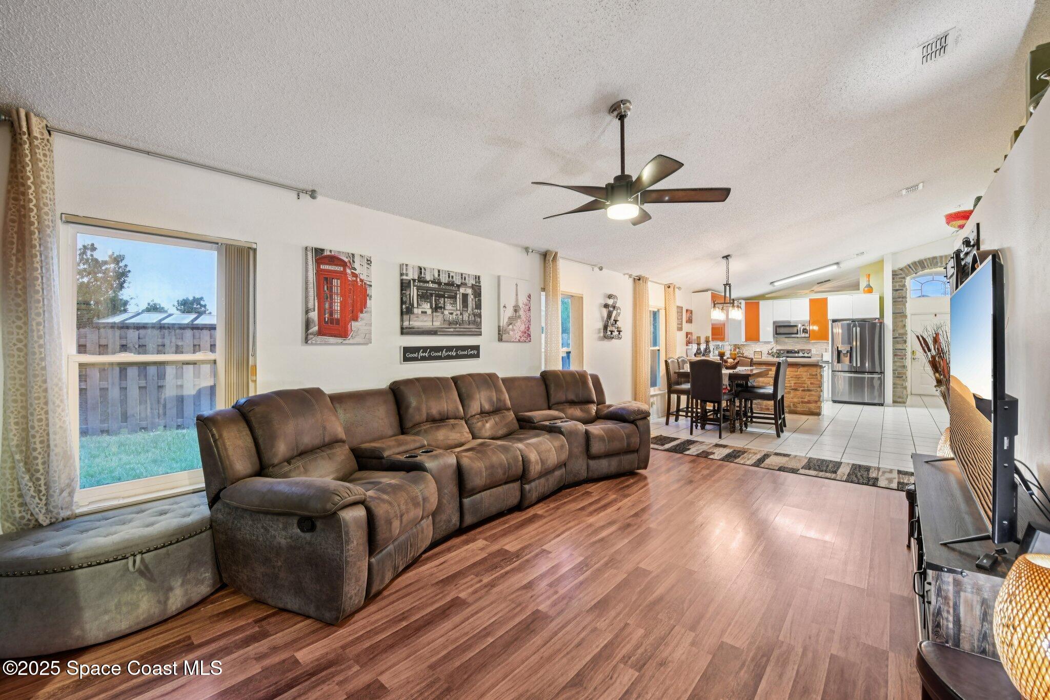 1125 Carey Glen Circle Orlando, FL 32824 - Photo 10 of 31 a living room with furniture a large window and a flat screen tv