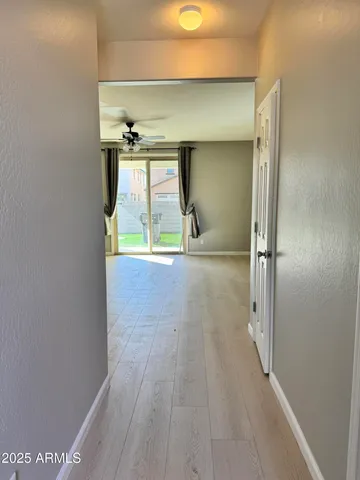 a view of a room with wooden floor and a ceiling fan