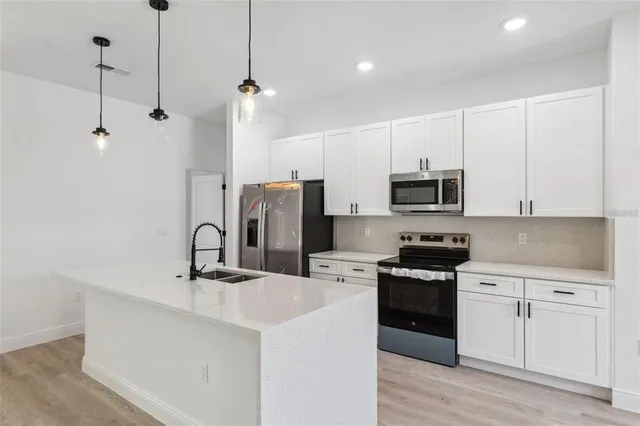 a kitchen with appliances a sink and cabinets