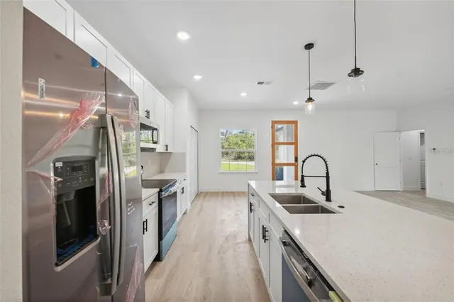a kitchen with kitchen island a sink appliances and cabinets