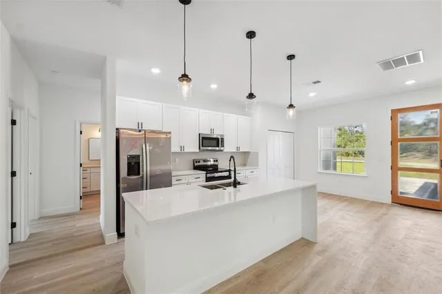 a kitchen with stainless steel appliances a refrigerator a sink and a stove