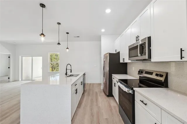 a kitchen with stainless steel appliances a stove sink microwave and refrigerator