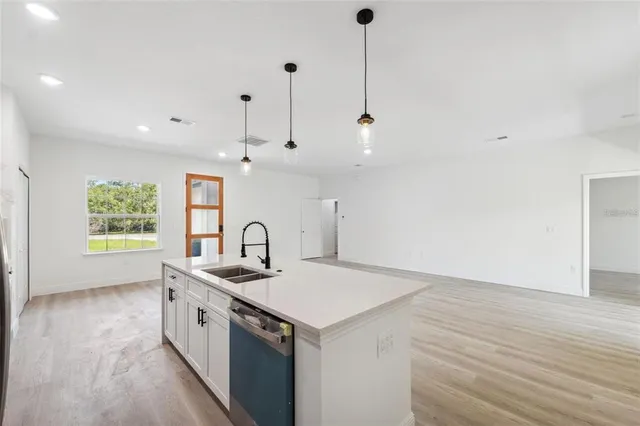 a kitchen that has a sink a stove and a wooden floor