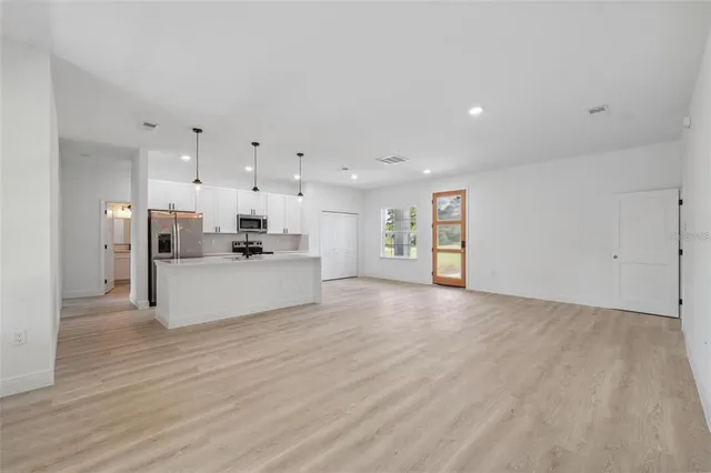 a view of kitchen with kitchen island white cabinets and refrigerator