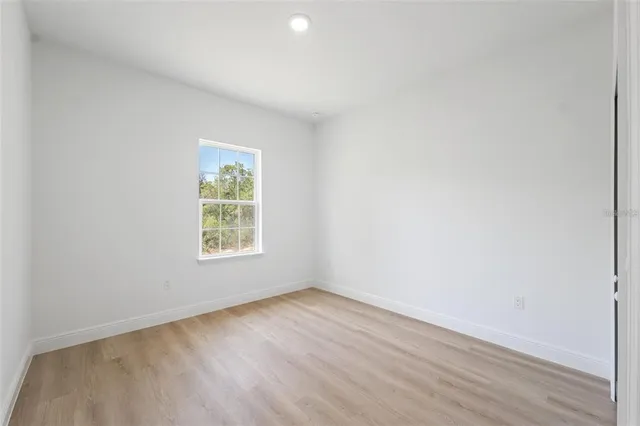 an empty room with wooden floor and a window
