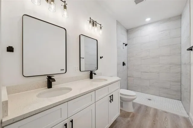 a bathroom with a sink a toilet and shower