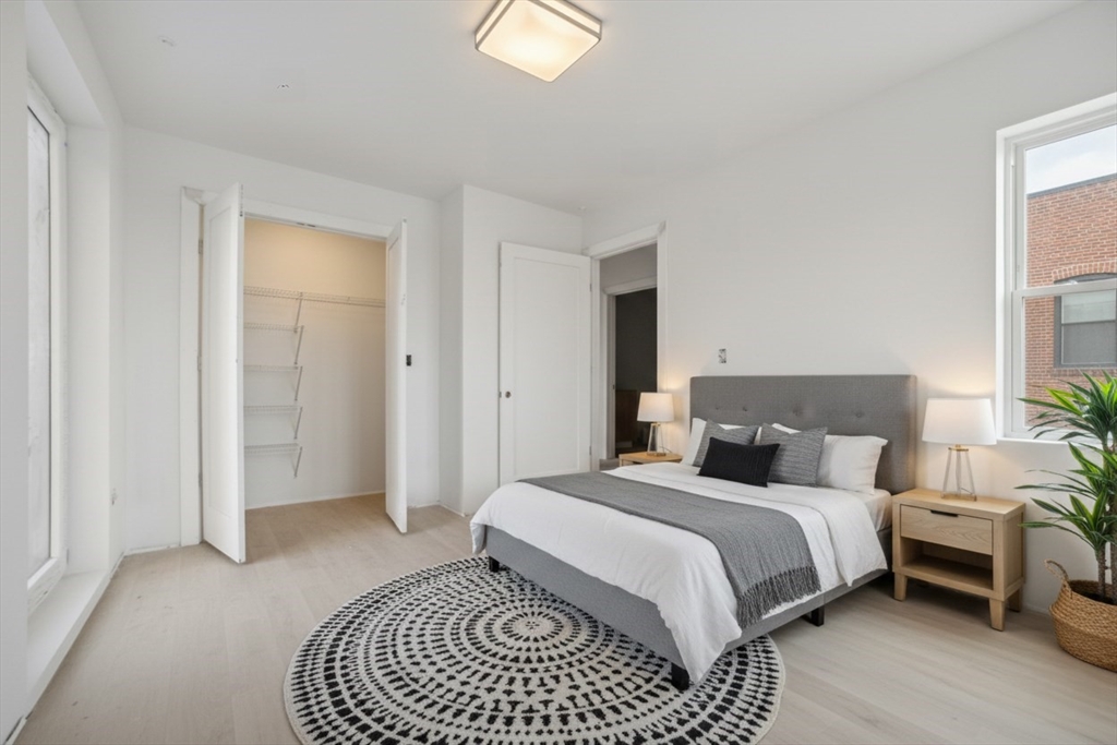 1035 Commonwealth Avenue, Unit 510 Boston, MA 02215 - Photo 7 of 16 a bedroom with a bed and a chandelier