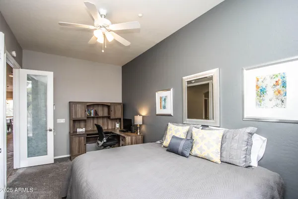 a bedroom with a large bed and a chandelier