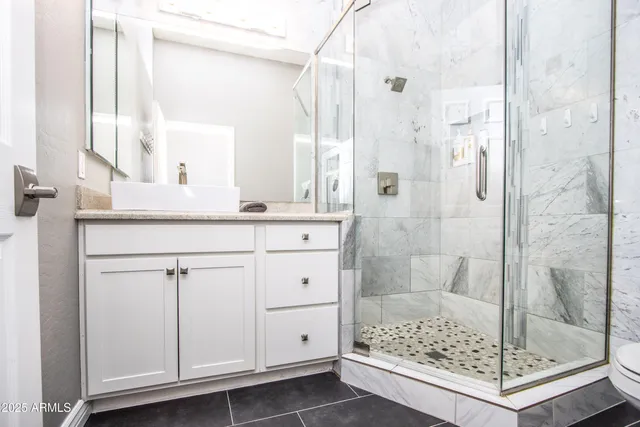 a bathroom with a shower and a sink a mirror