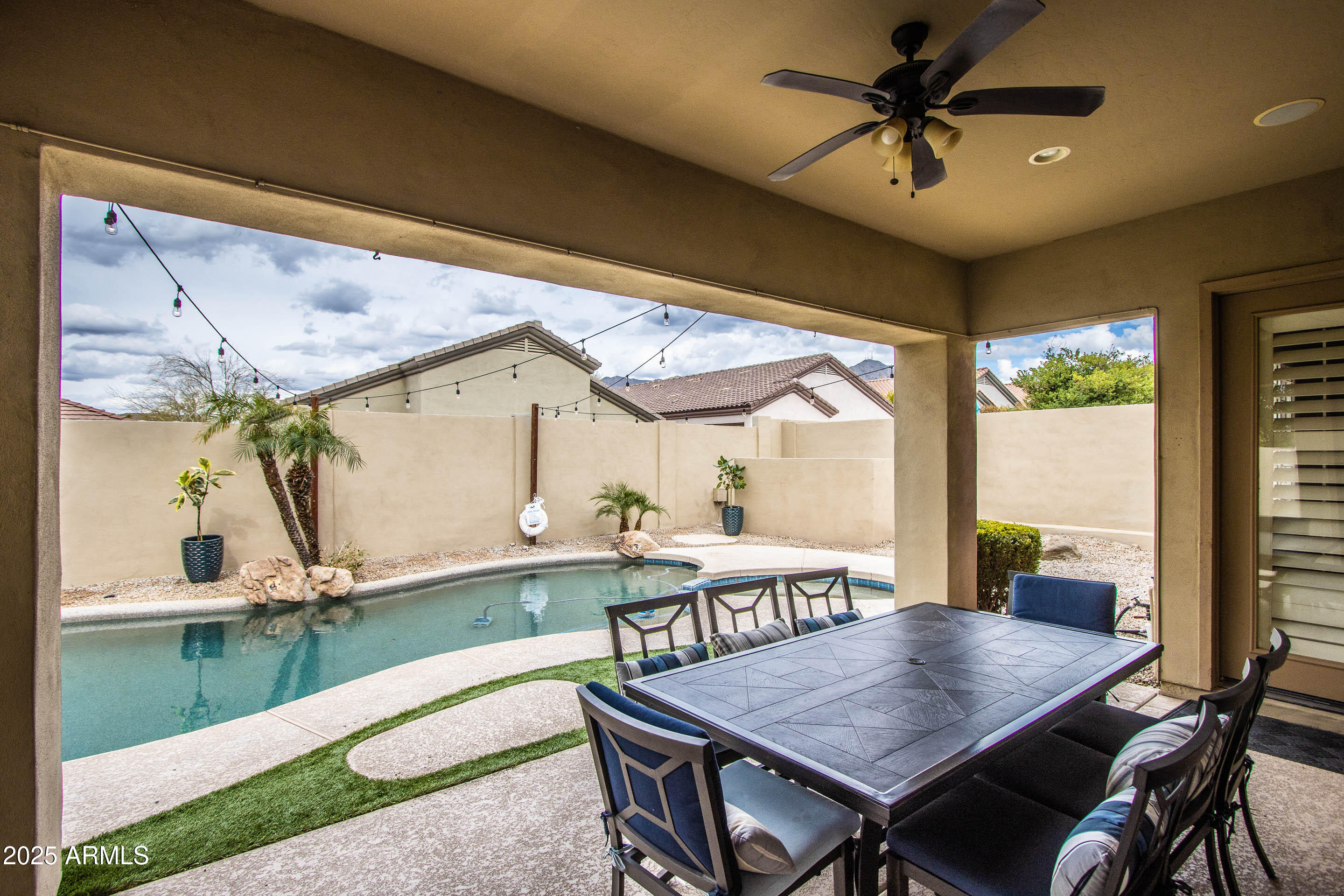 10412 East Acoma Drive Scottsdale, AZ 85255 - Photo 17 of 21 a dining room with wooden floor a chandelier fan a wooden table and chairs