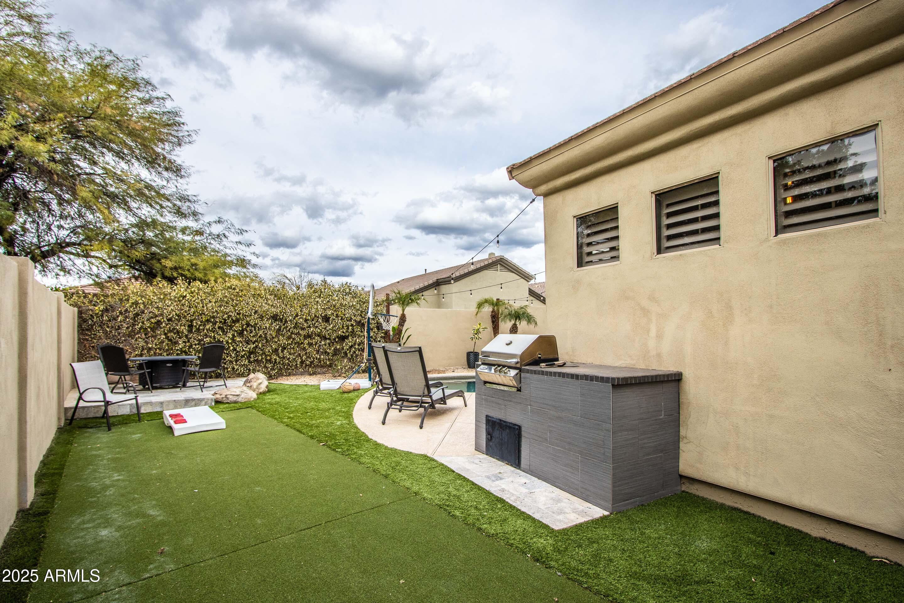 10412 East Acoma Drive Scottsdale, AZ 85255 - Photo 20 of 21 a backyard of a house with table and chairs