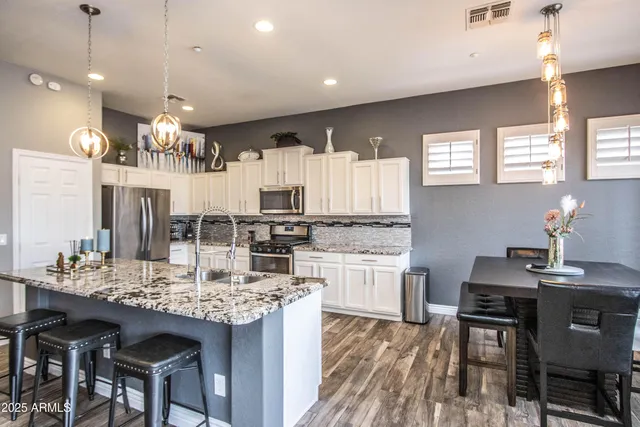 a kitchen with kitchen island granite countertop a sink and cabinets