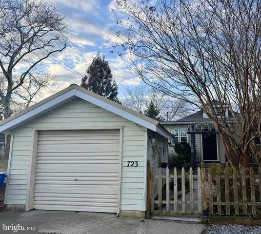 a view of a white house with large trees
