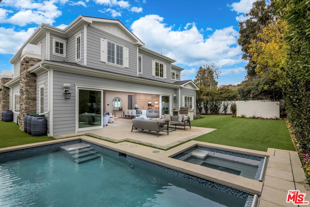 a view of a house with backyard sitting area and swimming pool