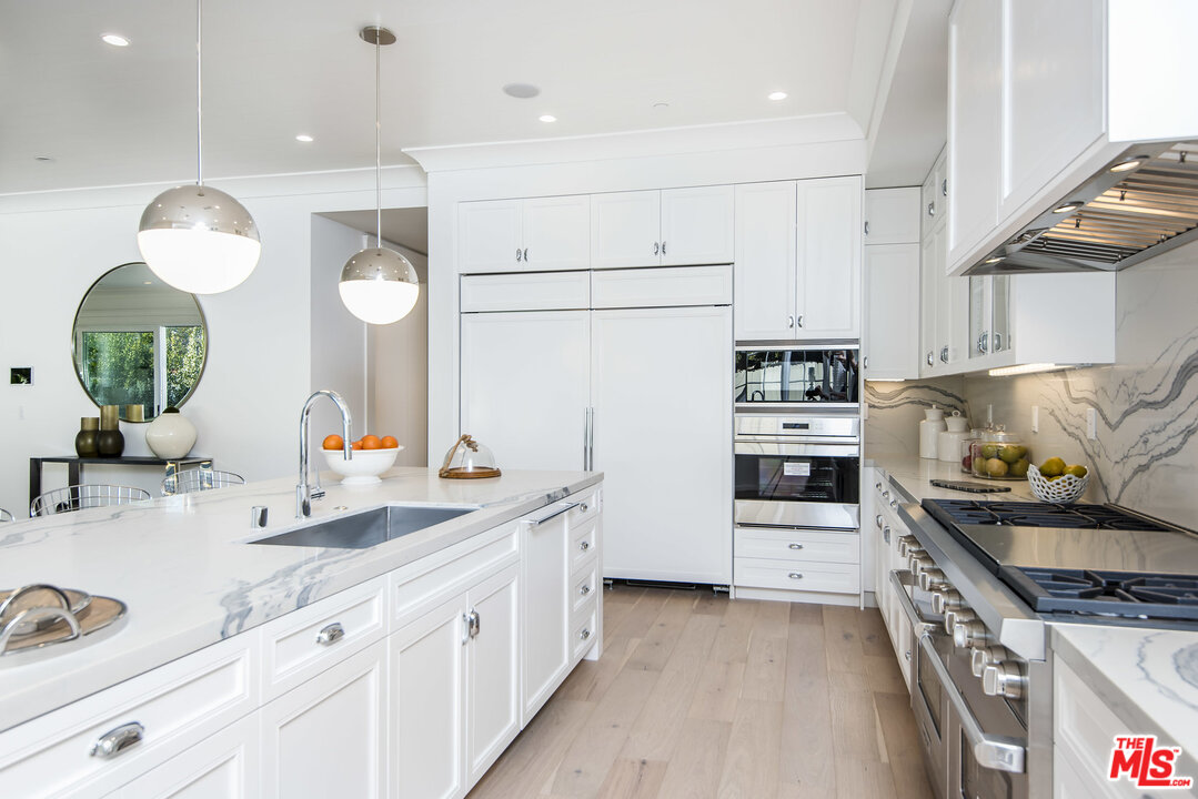 107 Larkin Place Santa Monica, CA 90402 - Photo 18 of 51 a kitchen with stainless steel appliances a sink stove refrigerator and cabinets
