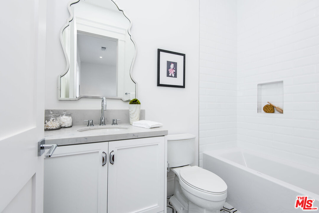 107 Larkin Place Santa Monica, CA 90402 - Photo 43 of 51 a bathroom with a granite countertop toilet sink and mirror