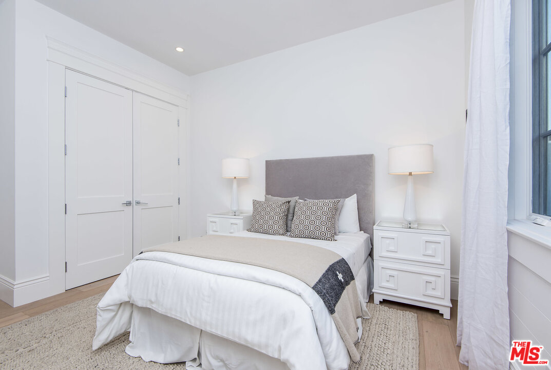 107 Larkin Place Santa Monica, CA 90402 - Photo 48 of 51 a bedroom with a bed a wooden floor and a table