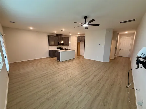 a view of a kitchen with wooden floor and a ceiling fan