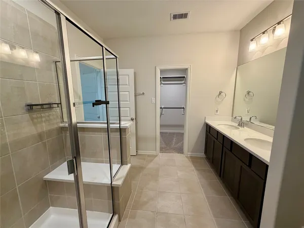 a bathroom with a double vanity sink toilet and shower
