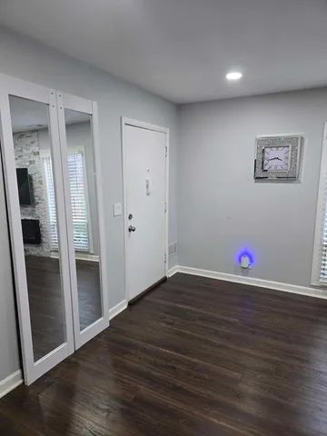 an empty room with wooden floor and closet