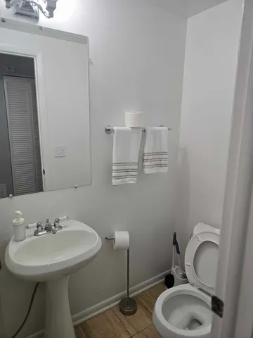 a bathroom with a sink mirror and toilet