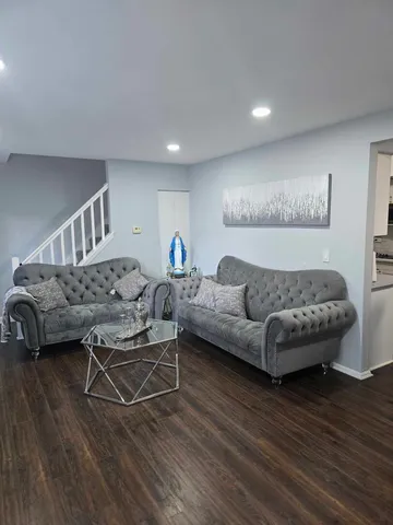a living room with furniture and a wooden floor