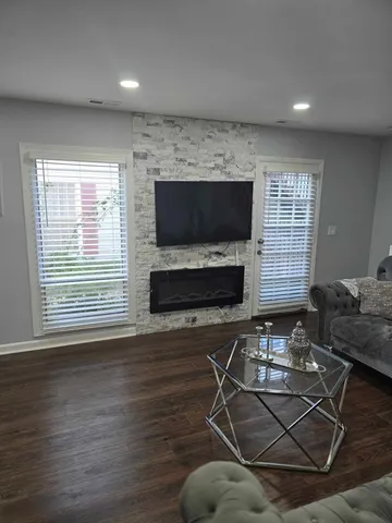 a living room with furniture a flat screen tv and a fireplace