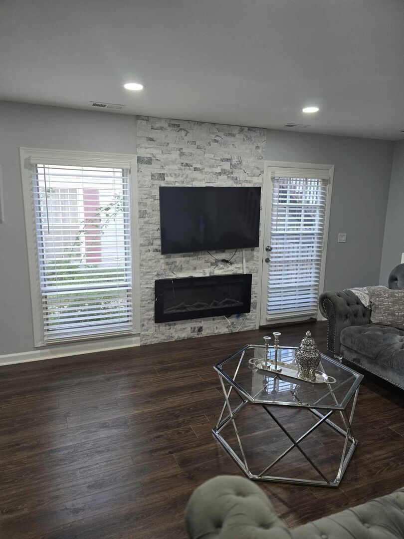 877 Wellington Avenue, Unit 1 Elk Grove Village, IL 60007 - Photo 6 of 25 a living room with furniture a flat screen tv and a fireplace