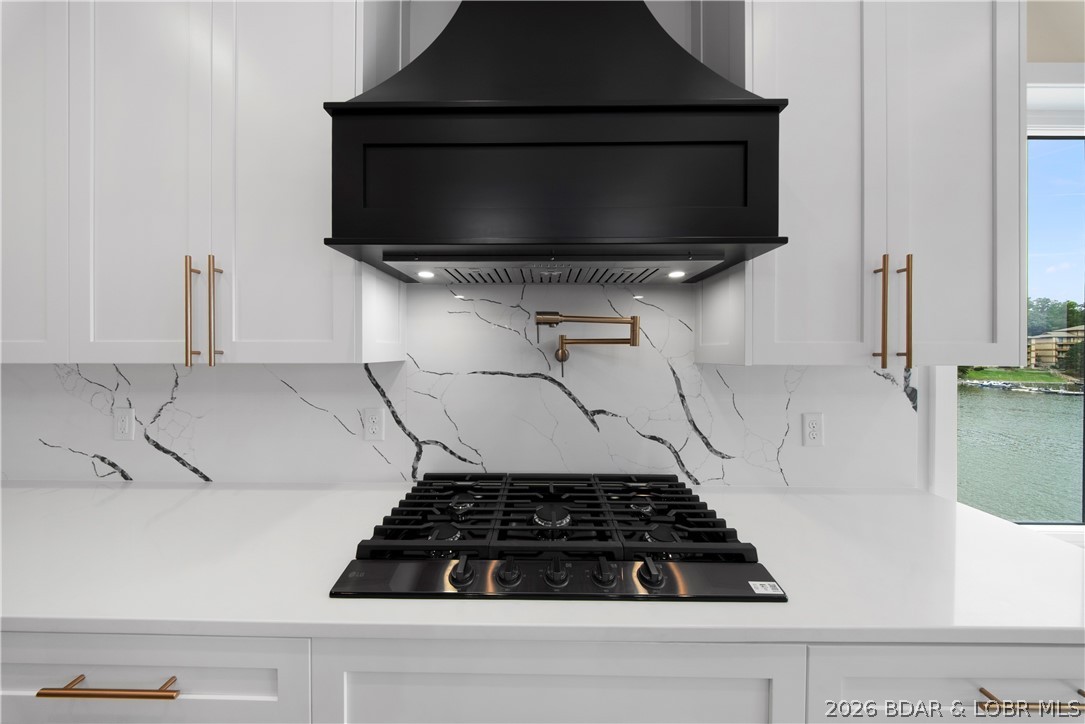 439 Red Bud Road Lake Ozark, MO 65049 - Photo 27 of 98 Professional-grade gas cooktop with custom vent ho