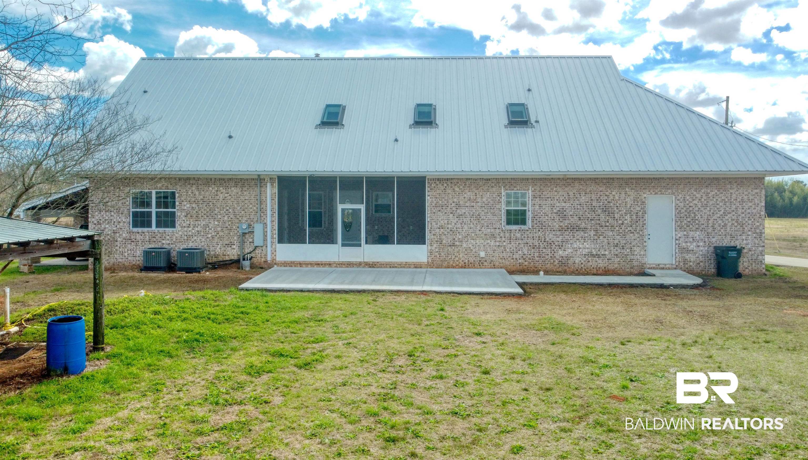 28461 Gardner Road Elberta, AL 36530 - Photo 32 of 46 Rear view of house with a metal roof, brick siding, and a lawn