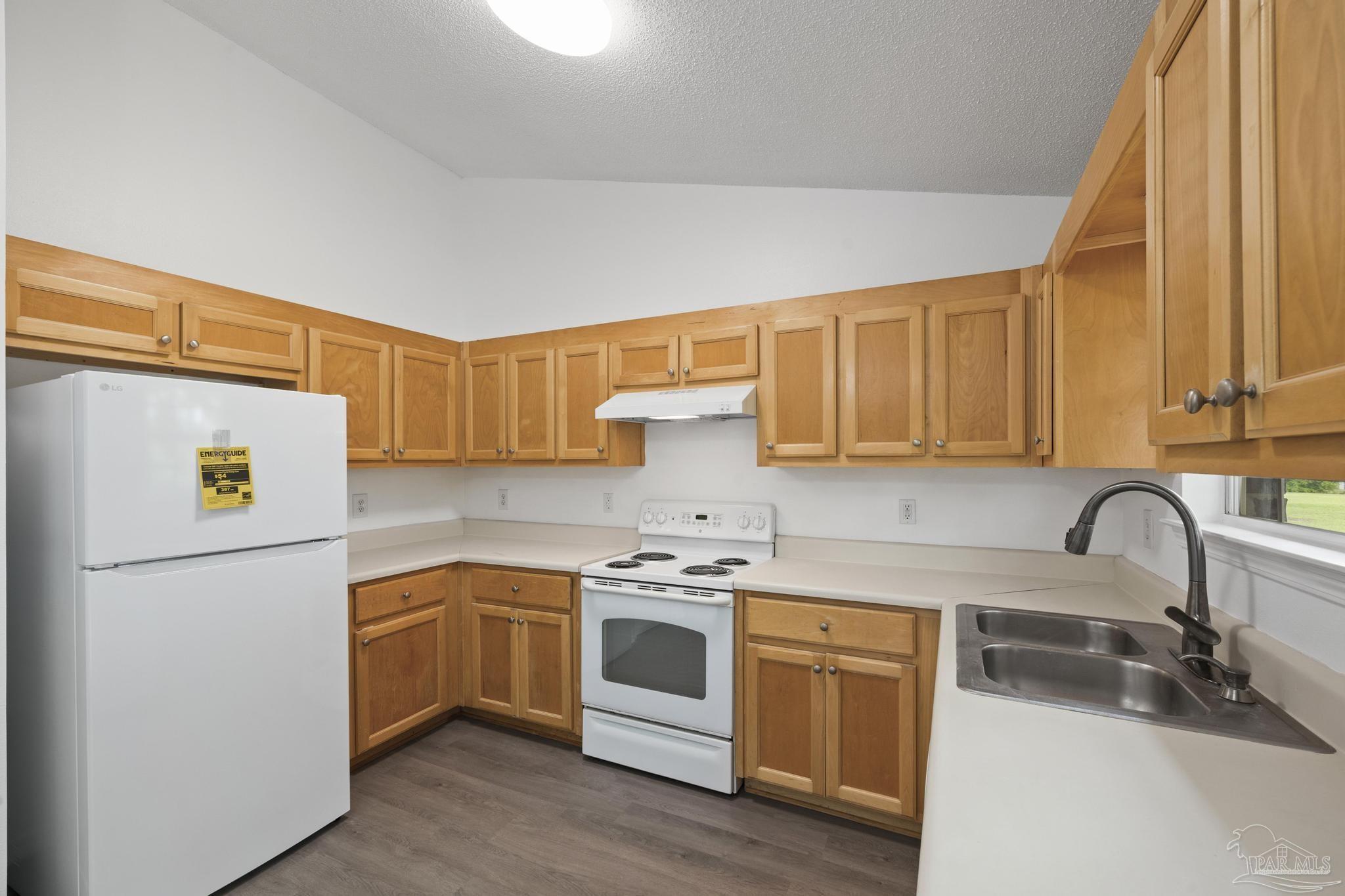 5564 Paddle Wheel Drive Milton, FL 32583 - Photo 11 of 41 a kitchen with white cabinets and white appliances
